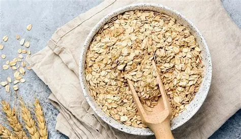 Tigela com aveia em flocos, frutas vermelhas, banana e mel, decoração rústica com colher de madeira
