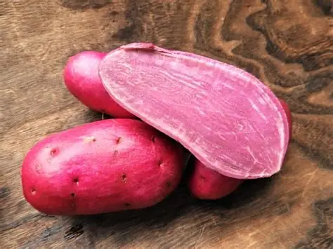 Batata Doce Roxa: O Superfood Roxo da Nossa Terra 1 Batatas doces roxas cortadas ao meio, mostrando a polpa roxa intensa, sobre tábua de madeira