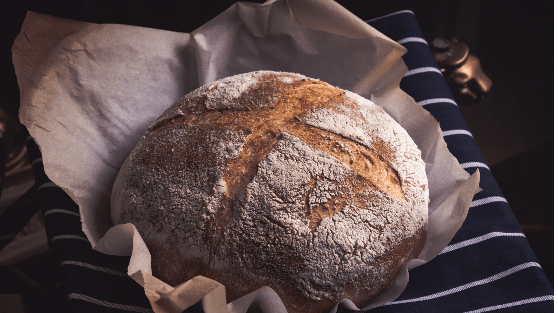 Fermentação Natural em Pães Artesanais 1 Pão artesanal com fermentação natural, crosta dourada e interior aerado, servido em cesto de rattan